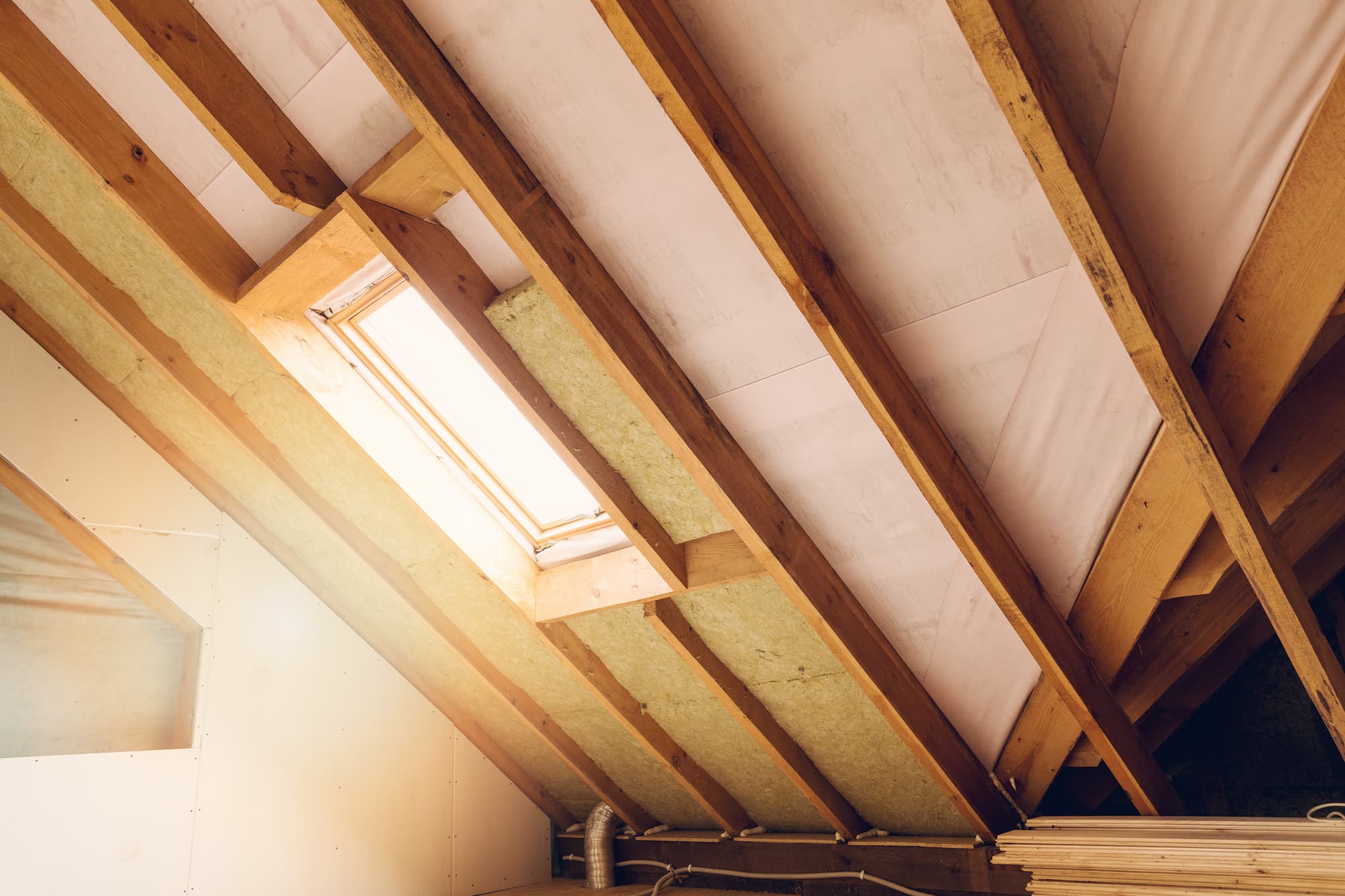 Loft conversion roof structure with thermal insulation installed between rafters during a Kingston loft conversion project by Sunny Build.