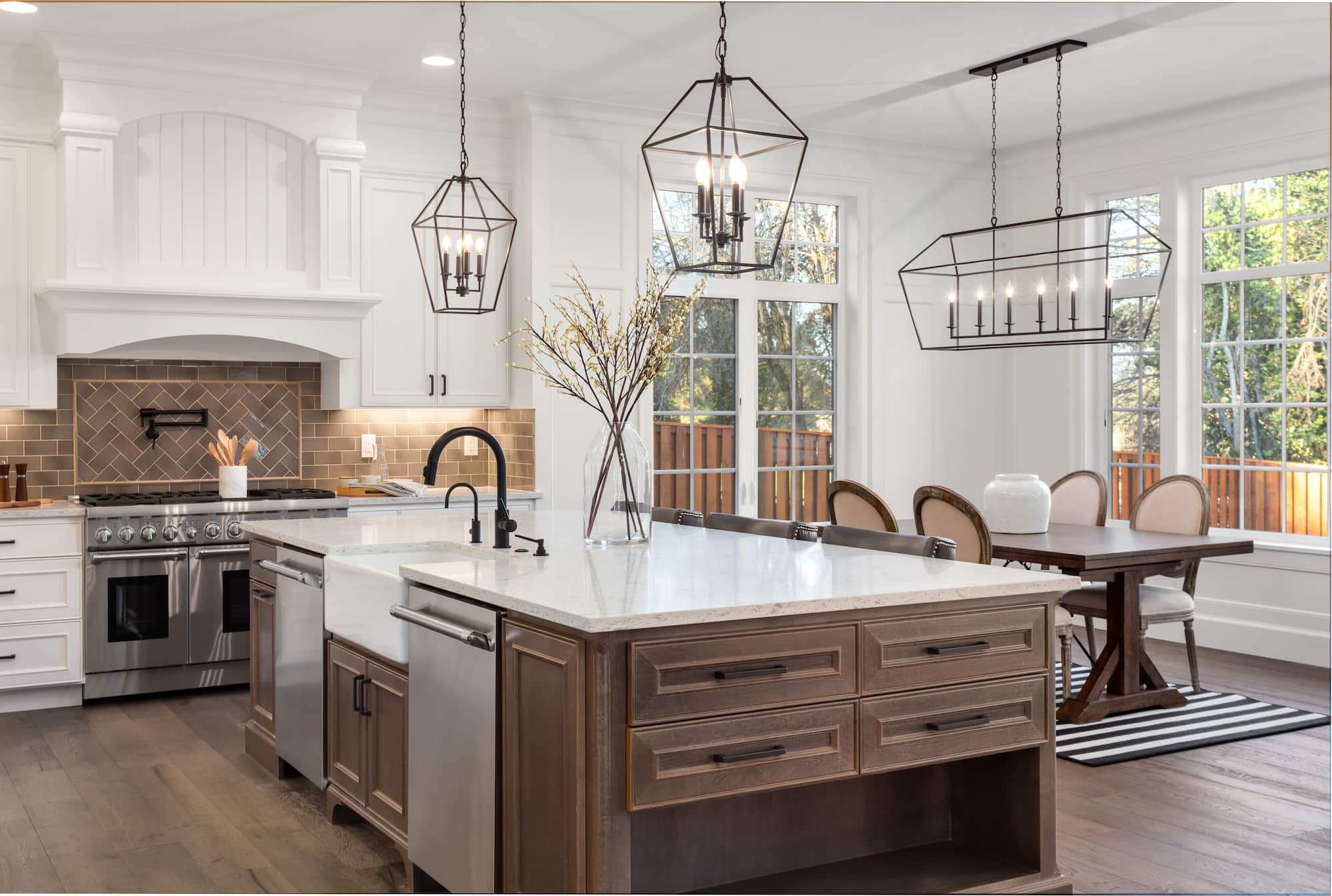 Bespoke kitchen renovation with large island, shaker-style cabinetry, statement lighting and open-plan dining area completed by Sunny Build in Kingston.