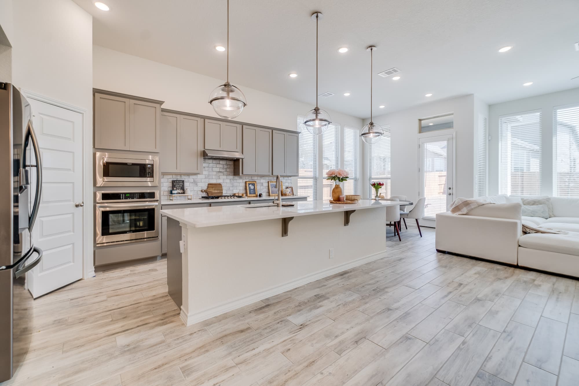 Bright open-plan kitchen and living area with central island, pendant lighting and modern cabinetry created by Sunny Build in Kingston.